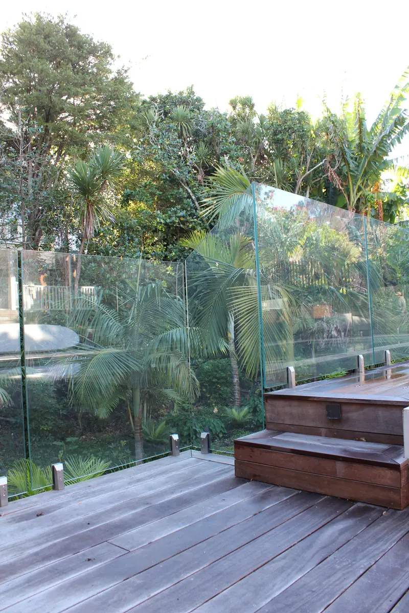 Frameless glass balustrade on a timber deck beside the pool