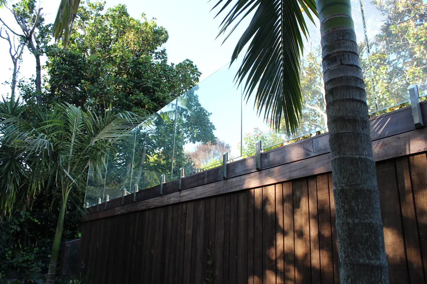 Glass panels carried along the top of a timber boundary fence