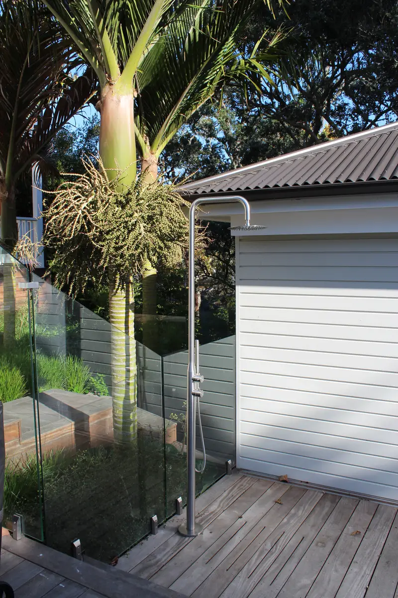 Outdoor shower beside the frameless glass pool barrier