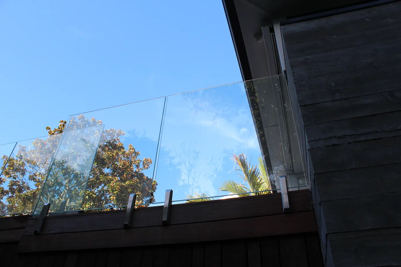 Detail of frameless glass panels against the sky