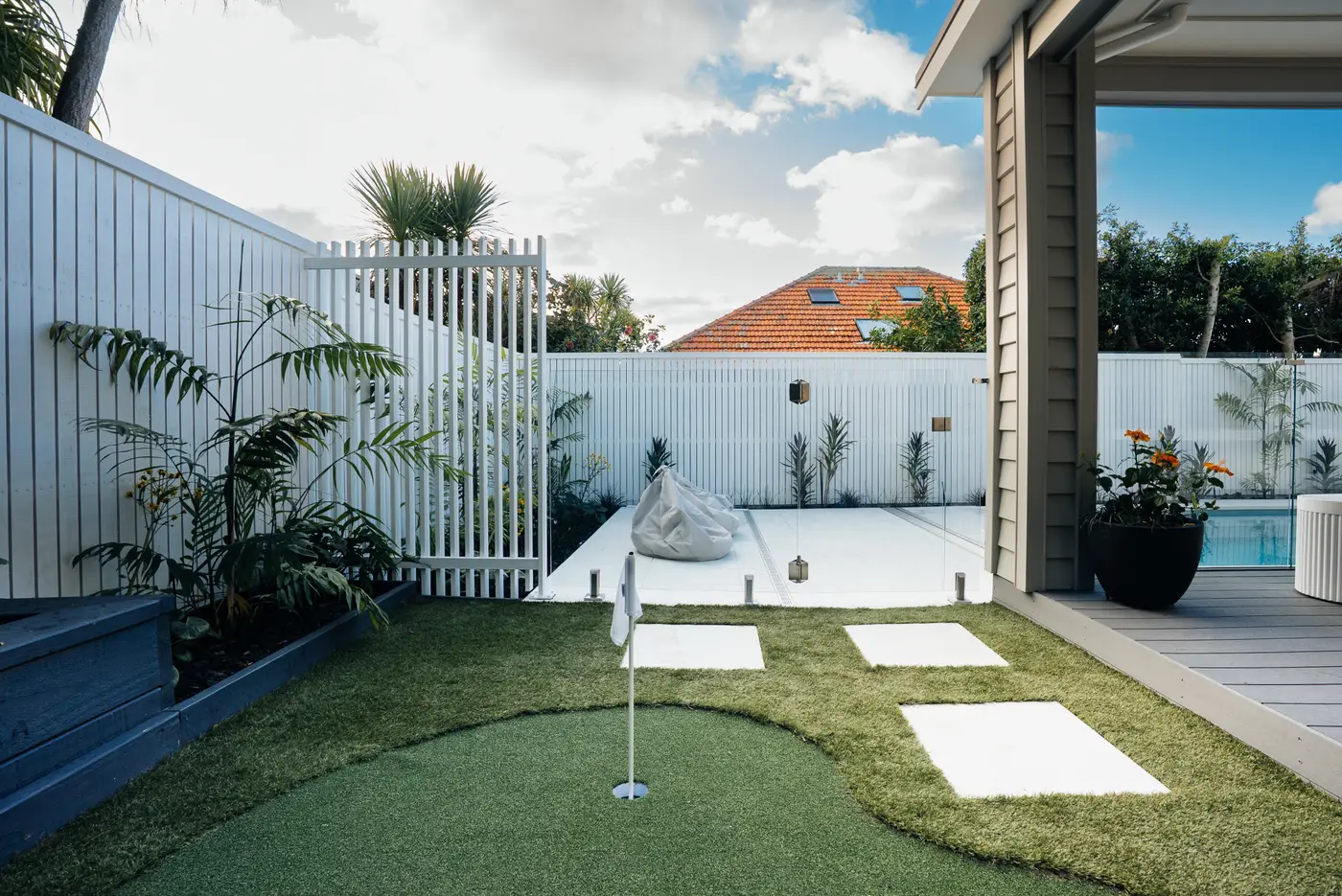 Putting green beside the aluminium screening and pool area