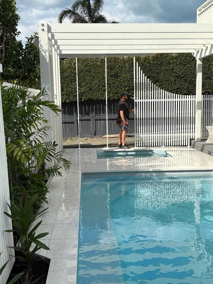 Installing white aluminium fencing beside the pool